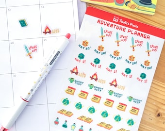 May include: A set of colourful stickers for an adventure planner. The stickers feature illustrations of dice, swords, campfires, teacups, books, and potions. The stickers are labelled with phrases like "Level Up!" and "Nat 20!"