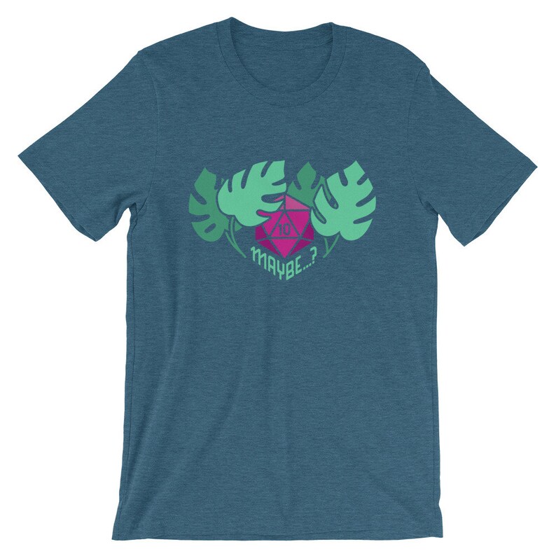 Puede incluir: Una camiseta azul turquesa con un gr&aacute;fico rosa y verde de un dado de diez caras rodeado de hojas. El texto "MAYBE...?" est&aacute; debajo del dado.