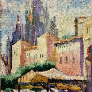 Può includere: Dipinto a olio di una scena di città europea con edifici nei toni del rosa, giallo e bianco. Il cielo è un misto di blu e bianco. Una scena di mercato è in primo piano con persone e ombrelli.