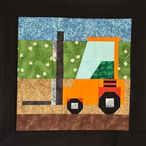 May include: A colorful quilt block featuring an orange forklift against a backdrop of a blue sky, green field with white flowers, and brown ground. The forklift has black wheels and a black smokestack. The quilt is set against a black background.