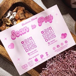 Può includere: Una carta rosa e bianca con il testo "Scan to Pay" in un font retrò. La carta include due codici QR, uno per Cash App e uno per Venmo. La carta elenca anche altri metodi di pagamento accettati, tra cui Apple Pay, PayPal e Zelle.