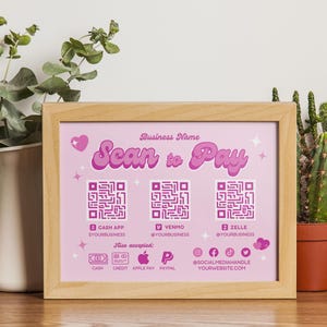 Puede incluir: Un cartel rosa y blanco con el texto "Scan to Pay" en una fuente retro. El cartel incluye tres códigos QR para Cash App, Venmo y Zelle. También enumera otros métodos de pago aceptados, incluyendo efectivo, crédito, Apple Pay, PayPal y los identificadores de redes sociales.