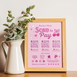 May include: A pink and white sign with the text "Business Name Scan to Pay" and a cherry graphic. The sign also includes QR codes for Cash App, Venmo, and Zelle, as well as icons for cash, credit, Apple Pay, and PayPal. The text "Leave us a review!" is at the bottom of the sign.