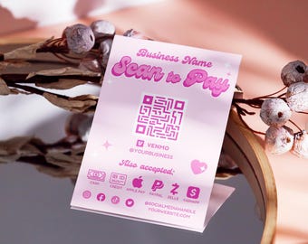 May include: Pink and white business card with the text "Business Name Scan to Pay" in a pink retro font. A QR code is in the center of the card. The text "VENMO @YOURBUSINESS" is below the QR code. The text "Also accepted" is below the VENMO text. Icons for cash, credit, Apple Pay, PayPal, Zelle, and Cash App are below the "Also accepted" text. Social media icons for Facebook, TikTok, and Twitter are below the icons. The text "@SOCIALMEDIAHANDLE YOURWEBSITE.COM" is below the social media icons.