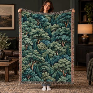 May include: A woven throw blanket featuring a dense forest pattern with various shades of green, teal, and dark blue foliage. The design depicts a thick canopy of trees with visible trunks and textured leaves, finished with a fringed edge.