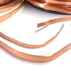 May include: Two pieces of copper sheet metal, one 1/4 inch wide and the other 1/8 inch wide. The copper sheets are bent into a curved shape.