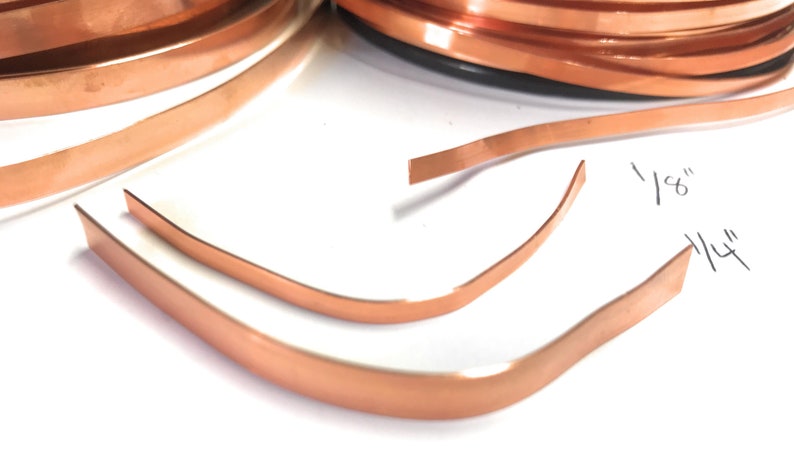 May include: Two pieces of copper sheet metal, one 1/4 inch wide and the other 1/8 inch wide. The copper sheets are bent into a curved shape.