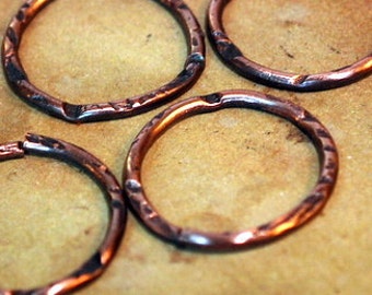 May include: Four copper rings with a hammered texture. The rings are slightly misshapen and have a rustic look.