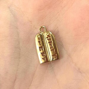 May include: Gold-toned pendant charm shaped like two tablets with Hebrew text.
