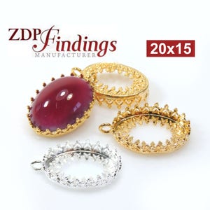 May include: Three oval-shaped metal settings for jewelry making. Two are gold-toned and one is silver-toned. The settings have a decorative crown-like design around the edges. The text "20x15" is visible in the image.