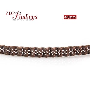 May include: A close-up of a 4.5mm wide copper metal trim with a decorative, openwork design. The trim has a slightly wavy shape and is ideal for adding a touch of elegance to craft projects.