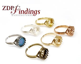 May include: Five adjustable ring settings with crown-shaped bezels. The bezels are silver, gold, bronze, and two antique gold. One ring has a blue stone in the bezel.