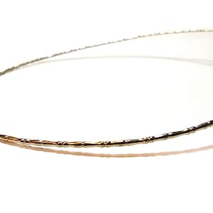 Puede incluir: Un brazalete de oro con un diseño delicado de cuentas.
