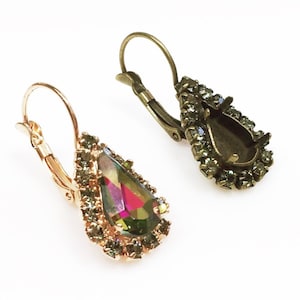 Könnte beinhalten: Ein Paar goldfarbene Ohrringe mit einem tropfenförmigen Kristall. Der Kristall ist schillernd und hat einen Regenbogeneffekt. Die Ohrringe haben einen Bügelverschluss.