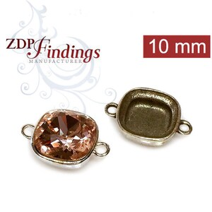 Puede incluir: Dos engastes metálicos plateados para una piedra cuadrada de 10 mm. Un engaste está vacío y el otro tiene una piedra cuadrada de color rosa claro.