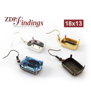 Può includere: Tre montature per orecchini, una con una pietra preziosa blu, in argento, oro e bronzo. Le montature sono rettangolari e misurano 18x13 mm. Il testo "ZDP Findings Manufacturer" e "18x13" è visibile nell'immagine.