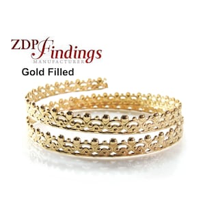 May include: Gold filled metal trim with a decorative design. The trim is coiled into a circle.