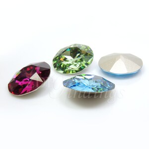 May include: Four faceted oval-shaped gemstones in shades of magenta, green, light blue, and silver. The gemstones are displayed on a white background, showcasing their cut and color variations. These gems are suitable for jewelry making.