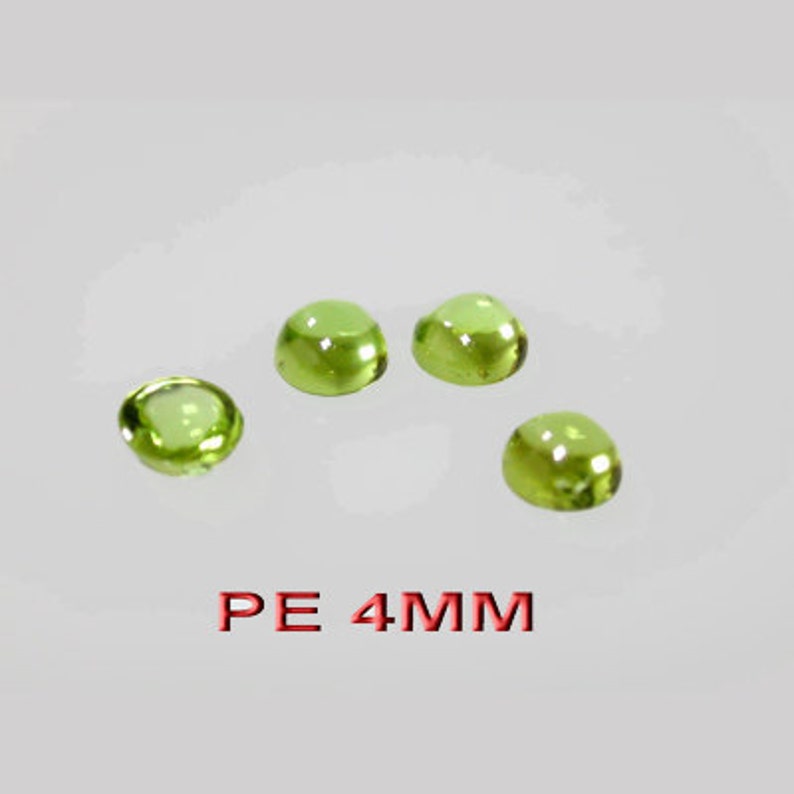 May include: Four green glass cabochons, each measuring 4mm in diameter. The cabochons are round and have a smooth, polished surface. The text "PE 4MM" is printed in red below the cabochons.