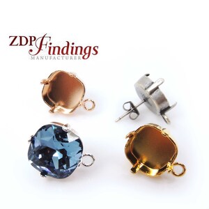 Op de afbeelding: Drie oorbelbevestigingen, een met een blauwe kristal, in goud, rosé goud en zilveren afwerking. De bevestigingen zijn vierkant met een afgeronde rand en hebben een lus om een ​​hangende bedel aan te bevestigen. De zilveren bevestiging heeft een steek achterkant.