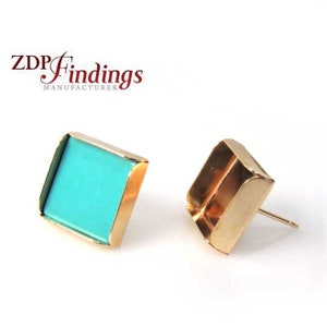 Peut inclure: Deux montures de boucles d'oreilles dorées de forme carrée. Une monture contient une pierre bleu turquoise. L'autre monture est vide.