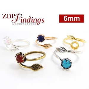 以下が含まれることがあります： 白いオパール、濃い青色の石、赤い石、ターコイズ色の石、金色のリングセッティングなど、さまざまな宝石をあしらった葉の形をしたリングの詰め合わせ。リングのサイズは6mmで、ZDP Findingsのものです。