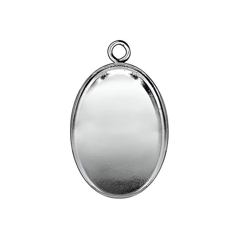 Peut inclure: Pendentif ovale en argent avec une surface lisse et r&eacute;fl&eacute;chissante et une boucle en haut pour attacher une cha&icirc;ne.
