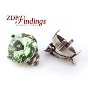 May include: A pair of silver tone clip-on earrings with a round, light green crystal setting.  The earrings are designed to hold a 10mm round stone.
