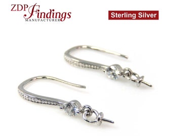May include: Two sterling silver earring hooks with a small, clear gemstone and a decorative beaded design. The hooks are curved and have a loop for attaching additional charms or beads. The text "Sterling Silver" is visible.