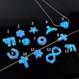 Puede incluir: Trece colgantes de ópalo azul en varias formas, incluyendo una estrella, un corazón, una cruz, una flor, una herradura, un símbolo de infinito y una luna creciente. Los colgantes están numerados del 1 al 13.
