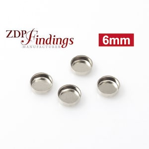 May include: Four silver-colored, round, metal, 6mm diameter, flat-bottomed, shallow trays.