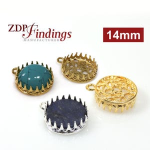 May include: Three 14mm round metal bezel settings for jewelry making. One setting is gold with a turquoise stone, one is gold with an open design, and one is silver with a blue stone.
