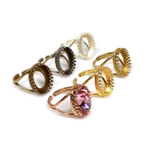 Puede incluir: Cinco engastes de anillo ovalados con un borde decorativo. Cuatro engastes están vacíos y un engaste tiene una piedra ovalada rosa.