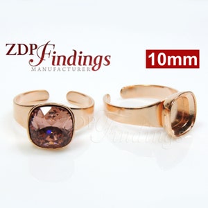 May include: Two rose gold adjustable ring settings with a 10mm square bezel. One setting is empty and the other has a light pink square crystal.