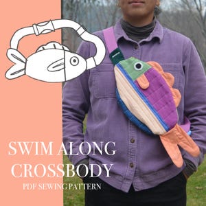 May include: A colorful fish-shaped crossbody bag with a pink strap. The bag features a patchwork design with shades of blue, green, purple, and orange. The text "SWIM ALONG CROSSBODY PDF SEWING PATTERN" is displayed on the left side of the image.