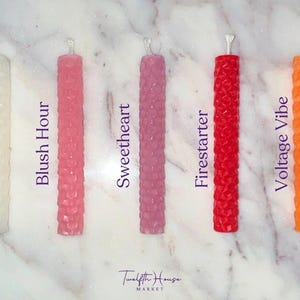 Puede incluir: Seis velas de diferentes colores con una superficie texturizada. Las velas est&aacute;n etiquetadas como "Blank Slate", "Blush Hour", "Sweetheart", "Firestarter", "Voltage Vibe" y "Twelfth House Market".