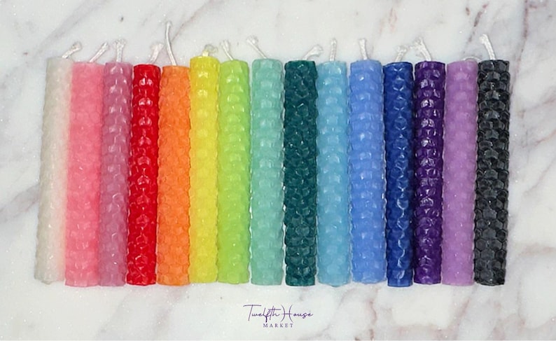 Puede incluir: Un conjunto de 15 velas de panal en varios colores, incluyendo blanco, rosa, lavanda, rojo, naranja, amarillo, verde, azul, morado y negro. Las velas est&aacute;n dispuestas en un patr&oacute;n de arco&iacute;ris.