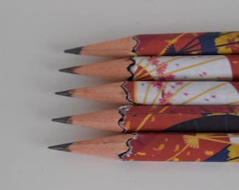 Könnte beinhalten: Nahaufnahme von fünf angespitzten Bleistiften mit dekorativen japanischen Designs. Die Bleistifte haben eine natürliche Holzfarbe mit roten, weißen und gelben Mustern. Die Bleistifte sind in einer Reihe angeordnet, mit ihren Graphitspitzen nach links.