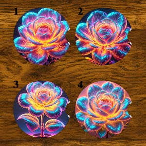May include: Set of four car coasters featuring vibrant, glowing rose designs. Each coaster showcases a different perspective of the flower, with petals in shades of blue, yellow, and pink. The coasters are round with a small notch for easy removal.