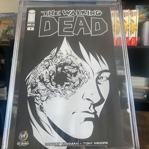 May include: A graded comic book of The Walking Dead #1, with a black and white cover featuring a close-up of a man's face with a horde of zombies behind his eye. The comic book is graded 9.6 by CGC.