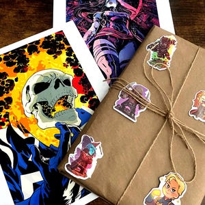 May include: A brown paper package wrapped with twine and decorated with colorful cartoon character stickers. The stickers feature characters like Ghost Rider, Thanos, Captain Marvel, and others.