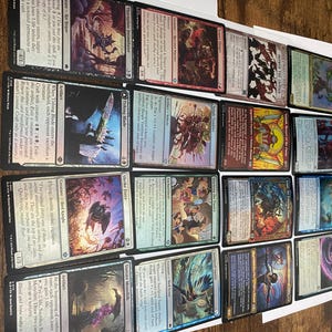 May include: A collection of Magic: The Gathering trading cards, featuring various creature and artifact cards. The cards display colorful illustrations and text, with card names like "Offspring", "Tithing Blade", and "Sinister Monolith".