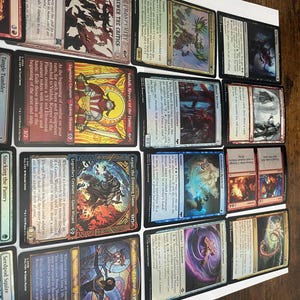 May include: A collection of Magic: The Gathering trading cards, featuring various creature and spell cards. The cards display colorful artwork and text, with titles like "Valduk, Keeper of the Flame" and "Aegar, the Freezing Flame."