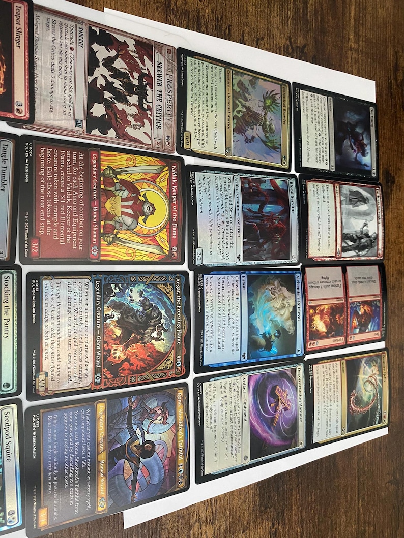 May include: A collection of Magic: The Gathering trading cards, featuring various creature and spell cards. The cards display colorful artwork and text, with titles like "Valduk, Keeper of the Flame" and "Aegar, the Freezing Flame."