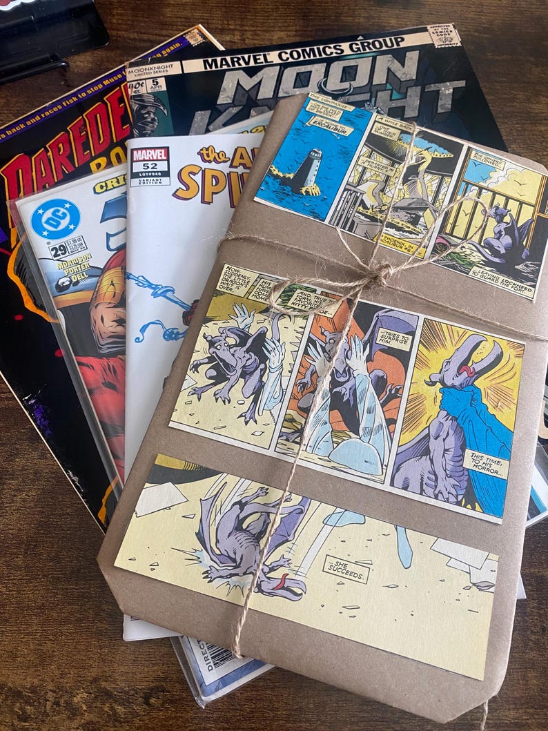 Pu&ograve; includere: Una pila di fumetti vintage tra cui Moon Knight, Daredevil e The Amazing Spider-Man, sormontata da un pacchetto avvolto in carta marrone legato con spago e decorato con pannelli a fumetti colorati raffiguranti creature simili a gargoyle.