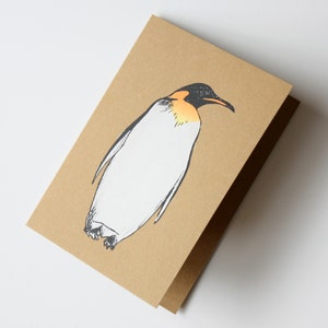 Tarjeta de felicitación navideña serigrafiada con pingüino sobre papel kraft de Fiona Hamilton