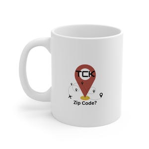 May include: White ceramic mug with a red and yellow graphic of a location pin with the text "TCK" and the words "Zip Code?" printed on the mug.