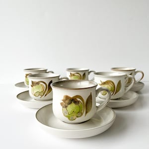 Può includere: Set di sei tazze da tè e piattini vintage con un motivo floreale in tonalità di verde, marrone e bianco.