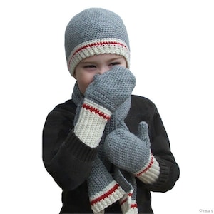 May include: A gray crocheted hat with a white and red stripe, matching gray crocheted mittens, and a gray crocheted scarf with a white and red stripe.