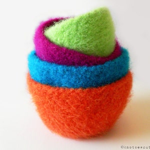 May include: A set of four felted bowls, nested together. The bowls are orange, blue, purple, and green.